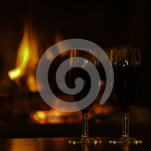 Glasses of red champagne by the fireplace