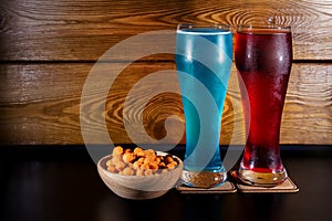 Glasses with red cider, blue ale  and orange crisp