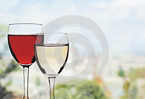 Glasses of red and white wine on blurred