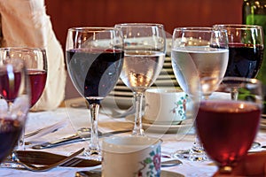 Glasses with red and white wine and coffee cups close-up. Served table in the restaurant