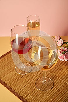 Glasses with red wine on a background of flowers and a mat