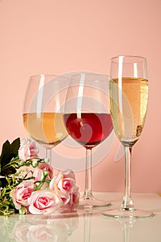 Glasses with red wine on a background of flowers and a mat