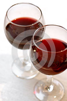 Glasses with red wine standing on table-cloth