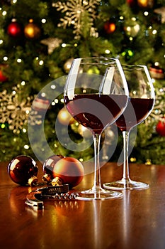 Glasses of red wine on table with Christmas tree