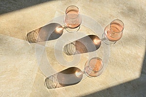 Glasses Of Rose Wine and Shadow on Stone Table