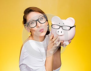 Glasses sale concept. Happy woman kissing piggy bank wearing eyewear glasses