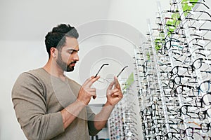 Glasses Shop. Man Trying On Eyeglasses In Optics Store