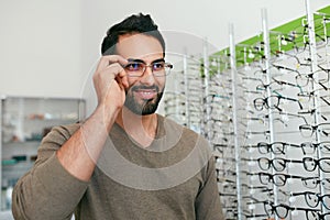 Glasses Shop. Man Trying On Eyeglasses In Optics Store