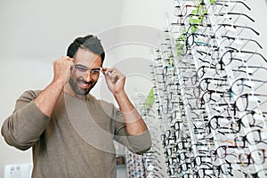 Glasses Shop. Man Trying On Eyeglasses In Optics Store