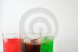 Glasses of soft drink with ice cubes and bubbles on wooden table kitchen