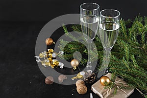 Glasses of sparkling wine, fir branches, chocolates with Golden wrappers, gift box, balloons, champagne, Christmas decor