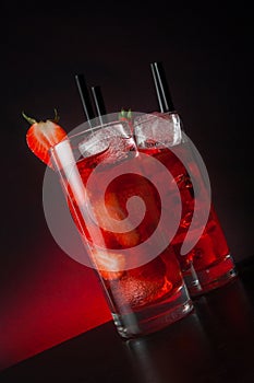 Glasses of strawberry cocktail with ice on wood table