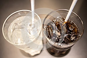 Glasses of sweet carbonated drinks with ice cubes