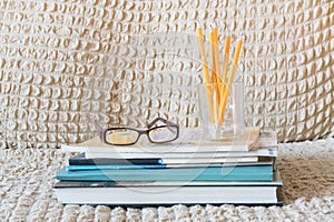 Glasses teacher books and a stand with pencils on the table. The concept of the teacher`s day. Copy space