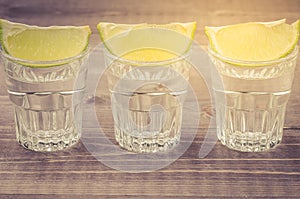 glasses of tequila with a lime stand in a row/glasses of tequila