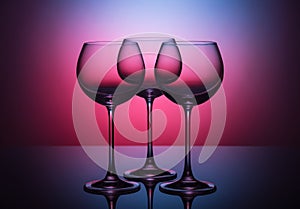 Glasses. Three empty glasses for wine on a colored background. Color coloring. In a low key