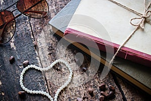 Glasses tied with a rope in a book with heart-shaped beads andnuts