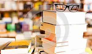 Glasses on top of different books lying on table in school libra