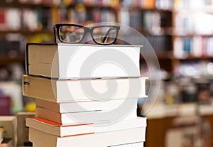 Glasses on top of different books lying on table in school libra