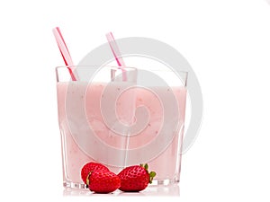 Glasses with useful strawberry smoothies, dyed cocktail tubes and a few strawberry berries. Isolated.