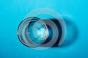 Glasses with water on blue background, top view