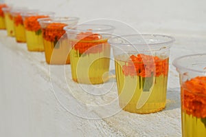 Glasses with water and carnation flowers at The Great stupa Bodnath in Kathmandu, Nepal.