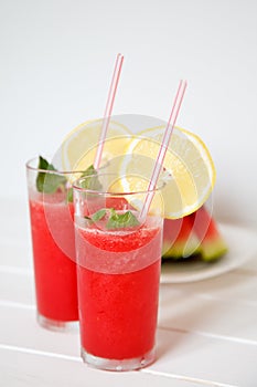 Glasses of watermelon smoothie and heartshapes on rustic wooden background