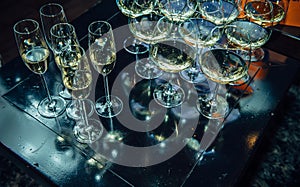 Glasses with a welcome alcohol drink on black wooden table, top view close-up