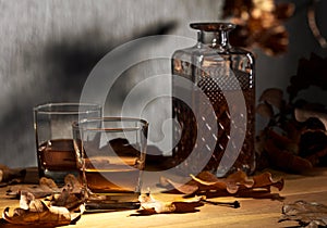 Glasses of whiskey on an oak table.