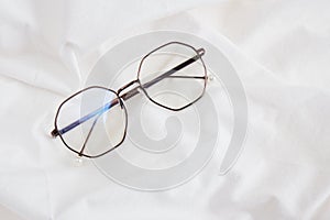 Glasses, on white fabric, spring mood concept, spend spring morning on bed, writing in notepad at home