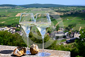 Glasses white wine from vineyards of Sancerre Chavignol appelation and example of flint pebbles soil, near Sancerre village, Cher