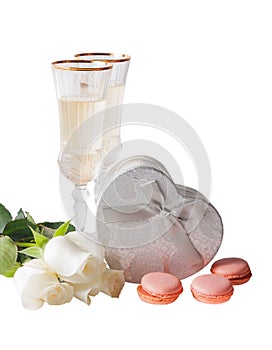 Glasses of white wine, white roses and silver gift box isolated