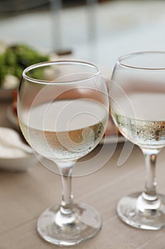 Glasses of white wine on wooden table, closeup