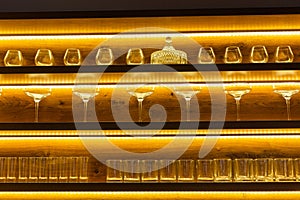 Glasses of wine. Glasses hanging above the bar in restaurant. Empty glasses for wine. Wine and martini glasses in shelf