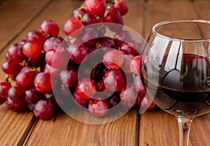 Glasses of wine and grapes on wooden background, copy space