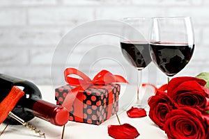 A glasses of wine, roses and gift