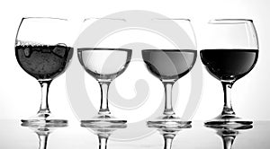 Glasses with wine on white background. A row of half-empty wine groceries. Four glasses with a variety of drinks