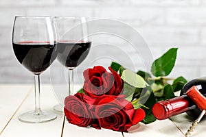 A glasses of wine, wine bottle and roses