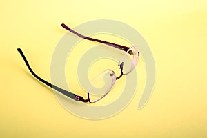 Glasses of a woman on a yellow background. Red frame glasses on yellow background. Myopia and hyperopia. Red rim glasses