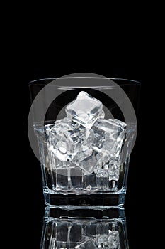 Glassful for whiskey with ice cubes isolated on black background