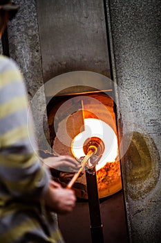 Glassmaker Flashing Piece of Glass in the Kiln