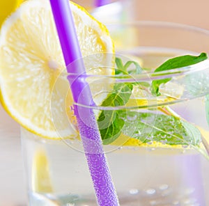 Glasss of mojito with lemon and drinking straw