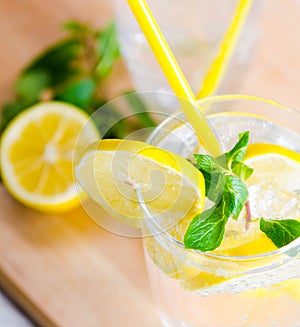 Glasss of mojito with lemon and drinking straw