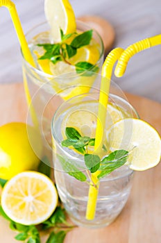 The glasss of mojito with lemon and drinking straw