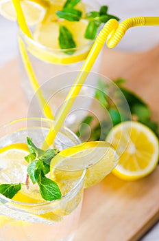 The glasss of mojito with lemon and drinking straw