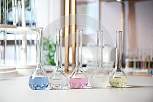 Glassware with colorful liquids on table. Laboratory analysis