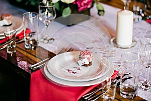 Glassware and cutlery for event dinner. Festive table with plates forks, knives, glasses, napkins and candle. Restaurant or cafe t