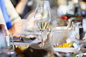 Glassware, glasses for white wine on a table in a restaurant. Banquet, cutlery, table setting. photo