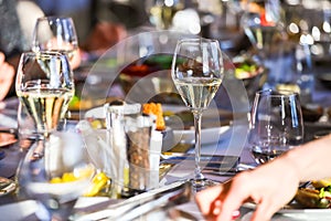 Glassware, glasses for white wine on a table in a restaurant. Banquet, cutlery, table setting. photo