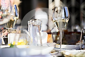 Glassware, glasses for white wine on a table in a restaurant. Banquet, cutlery, table setting. photo
